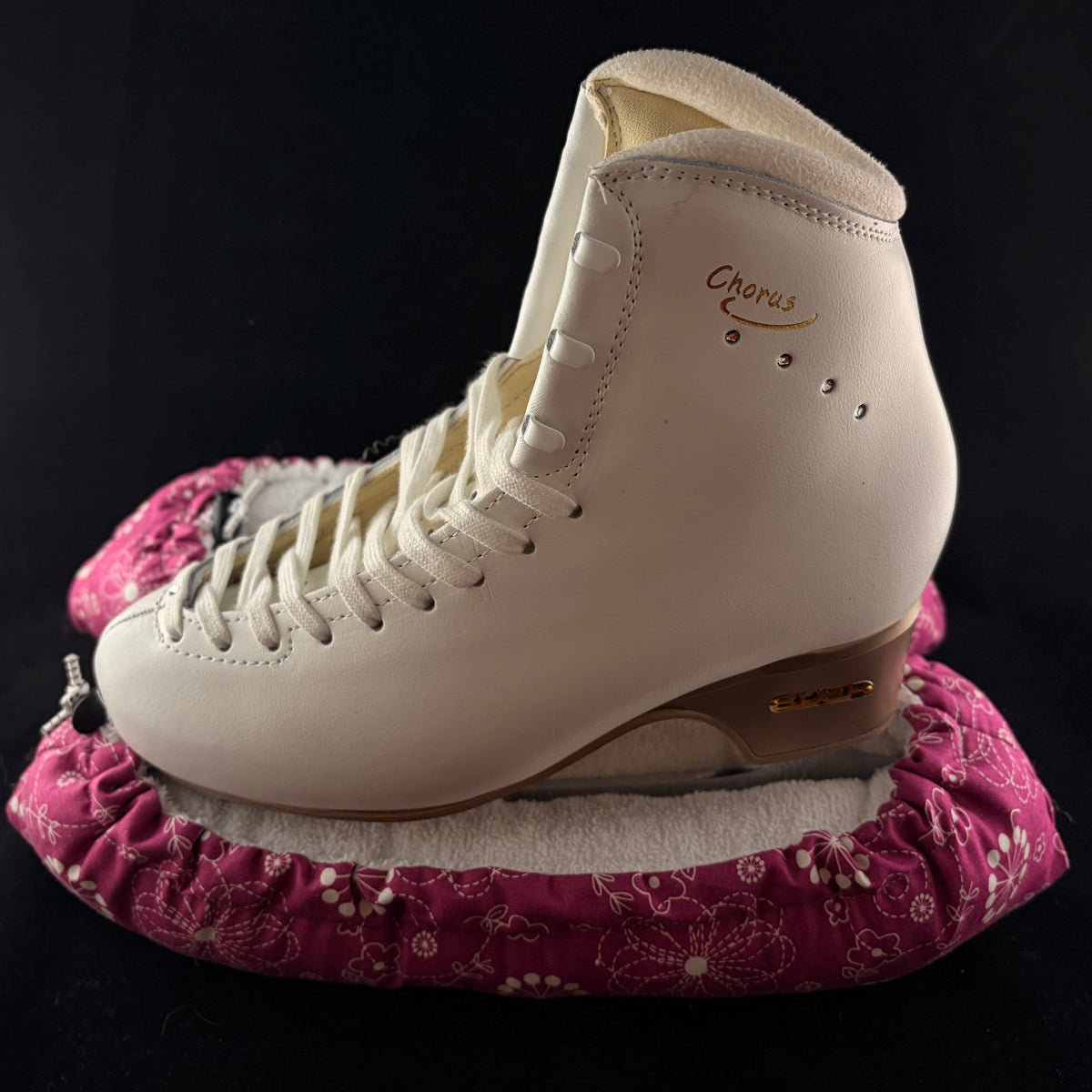 Pink floral blade soakers shown on a figure skate