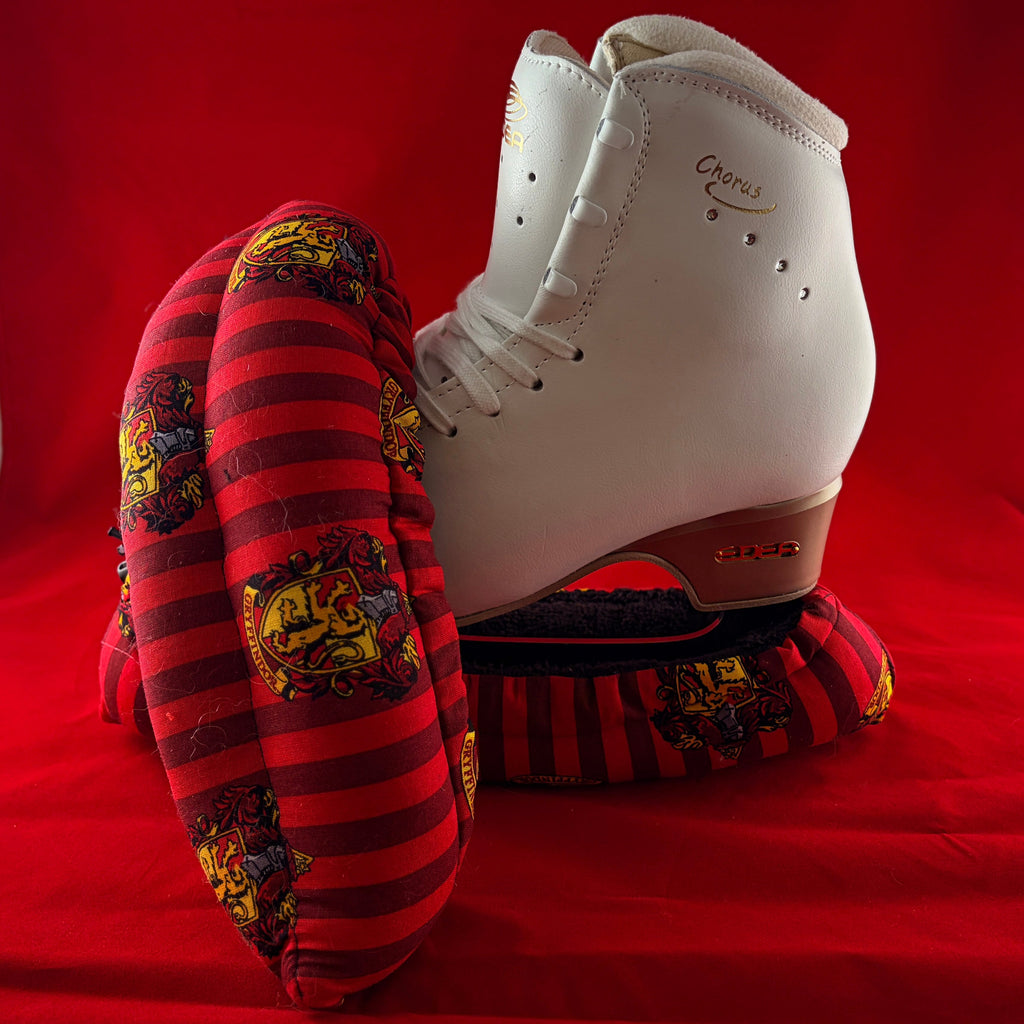 Red and gold wizard house inspired blade soakers shown on a figure skate